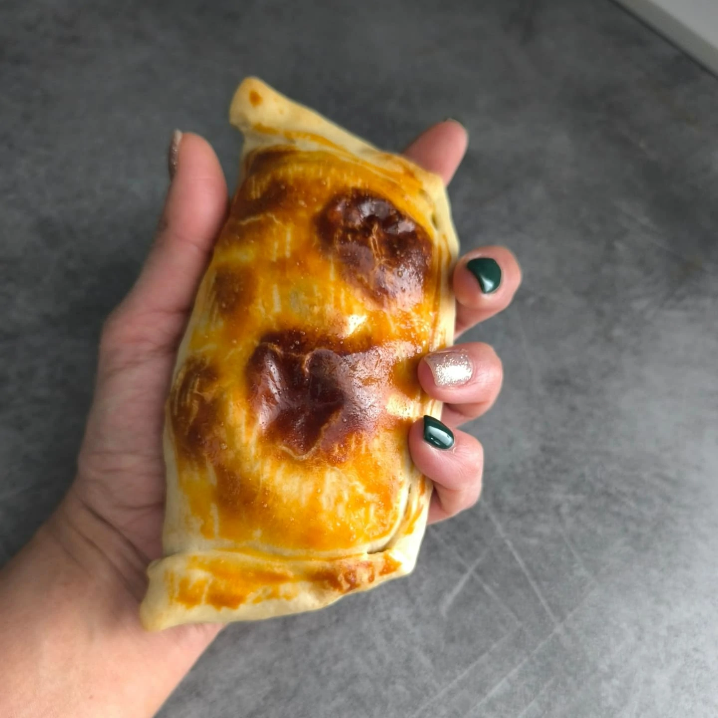 Grande empanada artisanale chilienne tenue en main