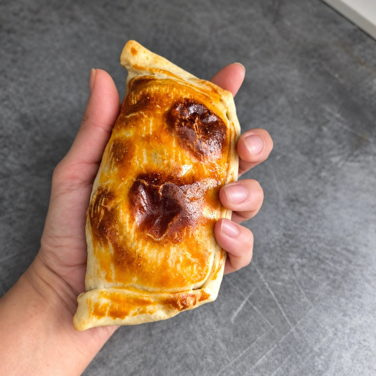 Grande empanada artisanale chilienne tenue en main